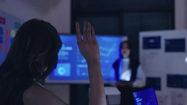 finanical investor asking question when leader reviewing data during a nighttime meeting financial projections and digital reports displayed on a screen