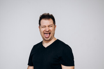 Obraz premium A man in a black t-shirt goofing around and squirming on camera