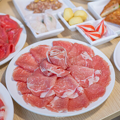 Delicious Assortment of Fresh Sliced Meat and Appetizers on White Plates - Perfect for Hot Pot or BBQ