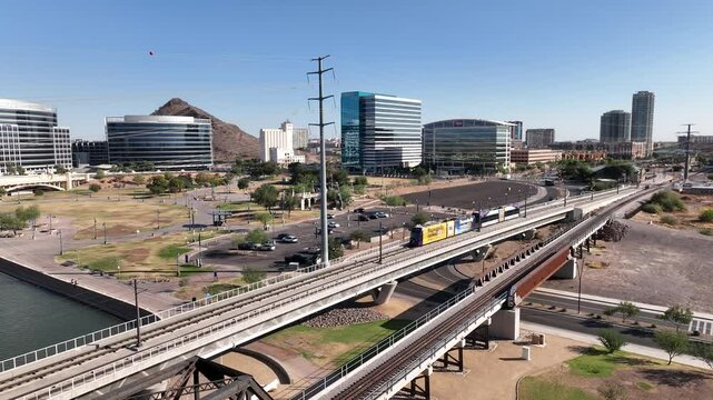 Aerial view of Tempe Town Lake with modern architecture, light rail, and city skyline, Tempe, United States.