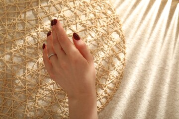 Woman wearing beautiful rings on beige background, closeup. Space for text