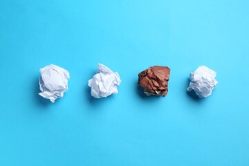 Stop racism. Crumpled paper pieces of different colors on light blue background, flat lay
