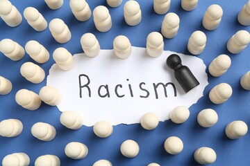 Card with word Racism and human figures of different colors on blue background, flat lay