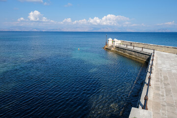 Fototapeta premium Coastal pier with people by the blue sea