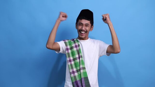 Asian muslim man celebrating success with clenched fist happy expression