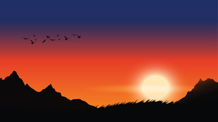 Beautiful sunset over mountains with birds flying across the colorful sky