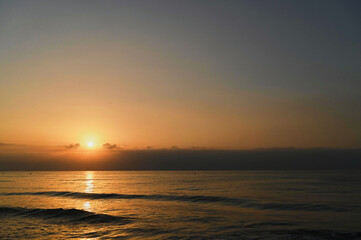As dawn breaks, soft golden hues spread across the sky. Gentle waves lap at the shore, creating a serene atmosphere filled with promise and tranquility.