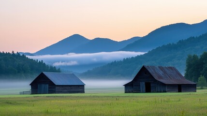 Obraz premium Serene Sunrise Misty Mountain Landscape with Two Rustic Barns