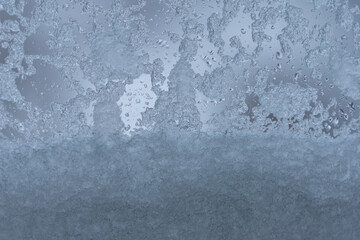 Glass covered with snow and water droplets