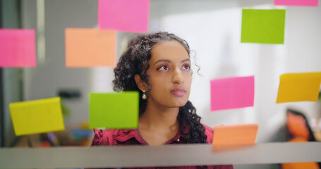 Close up of Indian young adult gen z woman lady read new notes look task data day time office glass...