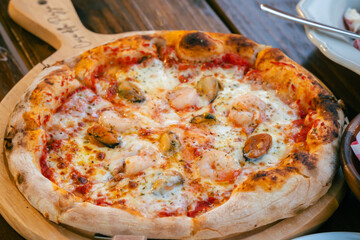  food  from Casa Della Pizza, in Kanchanaburi. The table is set with a delectable spread featuring a crispy, golden pizza topped with fresh a plate of perfectly spaghetti and bowl of  fruit salad