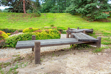 Rustic wooden benches invite relaxation in a serene garden setting. Copy space.