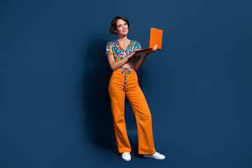 Full length photo of lovely young lady hold netbook working remotely dressed stylish flared pants...