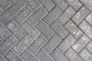 Interlocking Gray Paving Blocks in a Herringbone Pattern