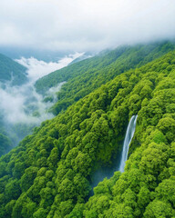 Misty waterfall cascading through lush green jungle landscape
