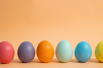 Bottom view close up of minimalist image of multi colored easter eggs lined up on light background, easter celebration concept