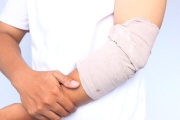 Bandaged Elbow Injury: Close-up of a Man's Arm with a Beige Bandage