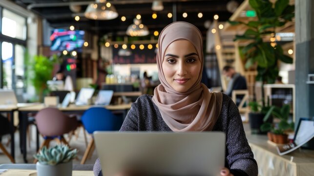Young entrepreneur wearing hijab working or study  remotely in a busy cafe