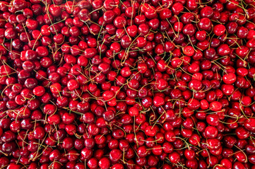 A vibrant, full-frame close-up of ripe, red cherries. Perfect for backgrounds, food blogs, or projects needing a fresh, juicy feel. Abundant, delicious, and naturally beautifu