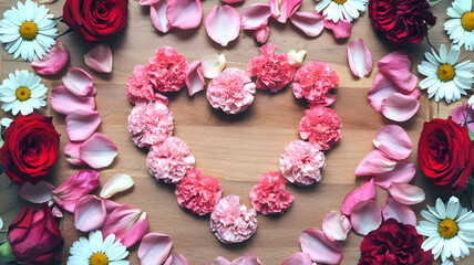 Romantic heart-shaped floral composition on wooden background, concept for weddings, valentine's day, and romantic gifts