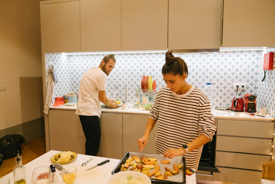 A couple is joyfully cooking together in their stylish and modern kitchen environment
