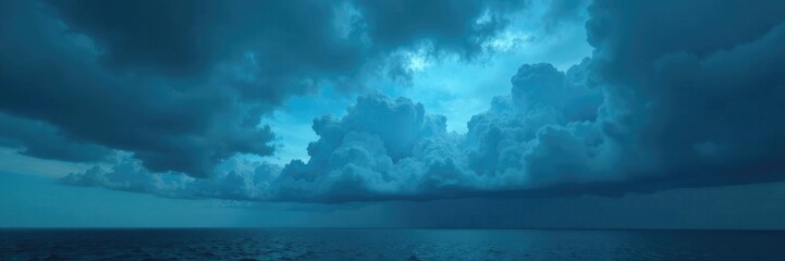 Naklejka premium Heavy gray cloud formation overhead with electric blue tint, , landscape
