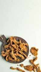 Crispy chicken skin, A wooden platter holds a variety of crispy fried snacks scattered around, perfect for sharing during a casual gathering