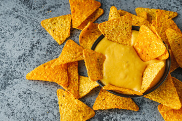 corn nachos with cheese sauce on a stone rustic background