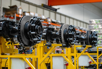 A row of black and silver tire axles on a yellow stand.