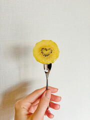 Hand holding kiwi on fork with heart shaped kiwi seeds
