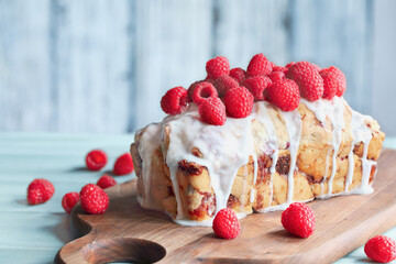 Raspberry Cake with icing and topped with fresh berries for the holidays. Selective focus with blurred background.
