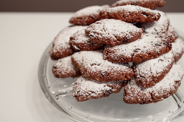 A stack of freshly baked Pan dei Morti cookies featuring rich cocoa flavor, almonds, and dried fruits, topped with powdered sugar, a classic dessert for Italian festivities