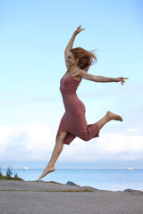Fototapeta premium Fitness female woman in dress jumping