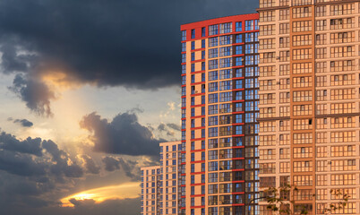 Fototapeta premium Modern buildings, walls and windows, reflections and sun rays. City view on a sunny day. 