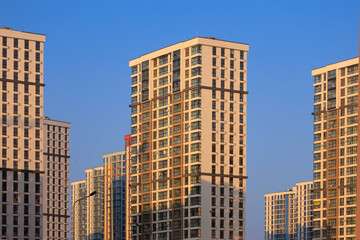 Obraz premium City view on a sunny day. Modern buildings, walls and windows. 