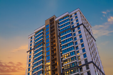 Modern buildings, walls and windows, reflections and sun rays. City view on a sunny day. 