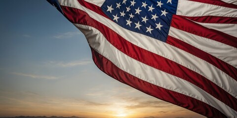 American flag waving in the wind at sunset over a scenic landscape