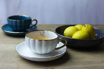 Cups of tea and lemons on wooden table, still life