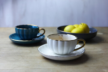 Cups of tea and lemons on wooden table, still life
