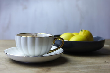 still life with white  cup of tea and bowl of lemons