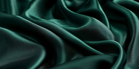 Deep emerald green silk fabric with soft folds, golden sparkles, and a refined glossy sheen, creating a sense of elegance and exclusivity