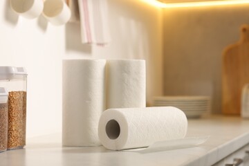 Rolls of paper towels on white marble countertop in kitchen