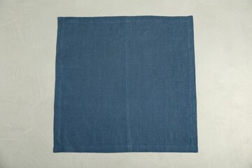 Blue napkin on light grey table, top view