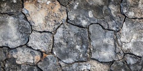 Obraz premium Worn-down ancient Roman road stone background with weathered, uneven cobblestones.