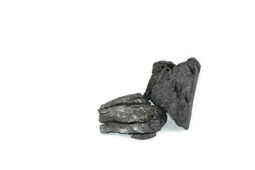 Isolated pieces of black charcoal resting on a clean white background, showcasing its rough texture and deep, rich color. Often used for grilling, art, and filtration.