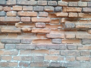 Fototapeta premium Old brick wall with fallen bricks