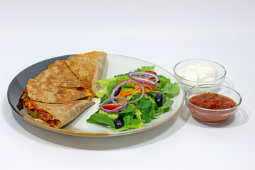 Quesadilla, Mediterranean salad, salsa and sour cream Mexican style food plate