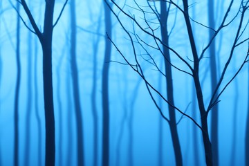 Obraz premium Mysterious blue forest with silhouetted trees.