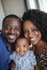 A smiling family of a man, a woman and a baby