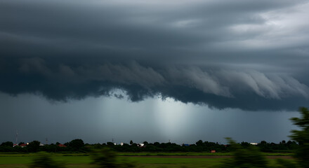 Dramatic monsoon sky with fast-moving dark clouds and a hint of rain falling in the distance